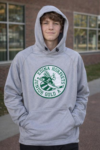 Person wearing a gray hoodie with a green and white logo in front of a brick building.