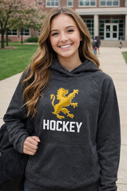 Person wearing a dark hoodie with a yellow lion logo and 'HOCKEY' text, standing outdoors.